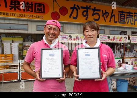 Seiichi Sato (L) presidente della frutta Marusei fattoria accanto alla moglie, mostra il JGAP (Giappone buone pratiche agricole) e Global GAP (buona pratica agricola) certificati della loro azienda frutticola Marusei Frutticolo durante il ''1000km staffetta a Tokyo 2018'' Promozione evento a Fukushima il 2 agosto, 2018, Giappone. L'evento annuale organizzato dal Governo Metropolitano di Tokyo, il Tokyo Associazione Sportiva e Tokyo Athletic Association vetrine i tentativi di recupero nel Tohoku area interessata dal 2011 Grande Oriente giappone terremoto. Il 15-giorno relè dalla Prefettura di Aomori a Tokyo è suddiviso in breve 1-2 Foto Stock