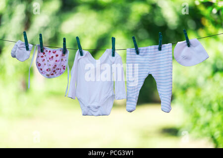 Vestiti del bambino su stendibiancheria in giardino Foto Stock