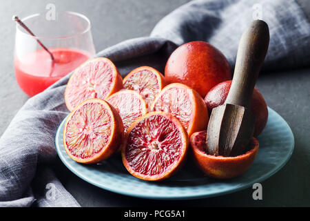 Rosso Arancio siciliano pezzi sulla piastra blu closeup Foto Stock