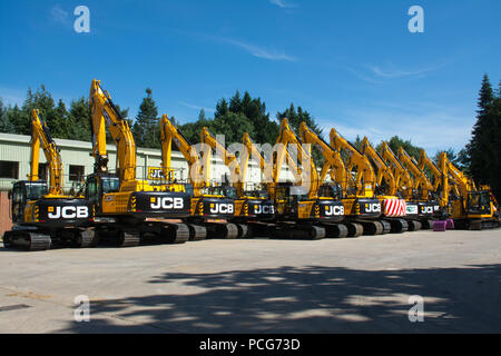 Greenshields JCB deposito, il concessionario e il distributore JCB di costruzione e di attrezzature industriali basato vicino a Farnham, Surrey, Regno Unito. Fila di giallo JCB escavatori. Foto Stock