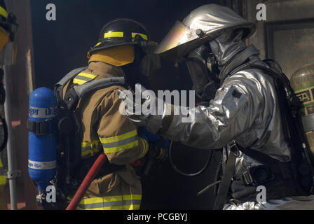 Un mentor dirige Afghan Air Force avieri in uno spazio contenente un fuoco durante un live masterizzare esercita su di Kandahar Airfield, Afghanistan.La Kandahar Air Wing condotta dal vivo un esercizio di masterizzazione per dare ai membri dell'AAF la possibilità di pratica lotta contro gli incendi in piena marcia e spazi ristretti. Foto Stock