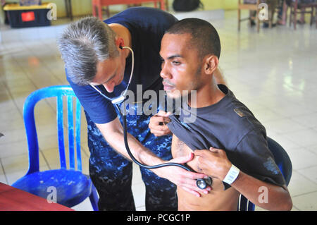 Stati Uniti Navy Lt. La Cmdr. Ira Nash, sinistra, imbarcato a bordo del militare comando Sealift nave ospedale USNS misericordia (T-AH 19), ascolta un uomo indonesiano il cuore durante un partenariato Pacifico 2010 medical civic programma di azione nel Tobelo, Indonesia, 15 luglio, 2010. Pacific Partnership 2010 è il quinto in una serie annuale di U.S. Flotta del pacifico ed umanitario assistenza civica sforzi per rafforzare i partenariati regionali. Foto Stock