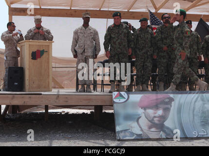 Esercito Nazionale Afghano laureati passo sul palco a ricevere il loro combattimento Medic completamento del corso certificato presentato da Ana di alti funzionari di leadership, qui, 7 luglio. Questa è stata la quarta edizione del corso. Durante la formazione di soldati ANA imparato le competenze di un medico di emergenza esigenze tecnico nel campo. Foto Stock