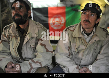 Afghan Polizia locale di ascoltare come un esercito nazionale afghano delle forze speciali Commando dà una breve prima di condurre una pattuglia di sicurezza nel quartiere Latif, provincia di Ghazni, Afghanistan, 3 aprile. Pattuglie di sicurezza vengono utilizzati per coinvolgere enti locali afgani e di sviluppare un rapporto con i principali leader del settore. Foto Stock