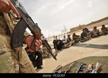 Afghan Polizia Locale reclute pratica posizioni di sparo con la loro AK-47 fucili a canna rigata durante un dry-Incendio campo classe nel quartiere Nawbahar, provincia di Zabul, Afghanistan, Marzo 24. La classe è parte di tre settimane di corso che insegna ALP candidati base procedure di polizia, armi di manipolazione e altre competenze necessarie per proteggere e difendere i cittadini afghani. Foto Stock