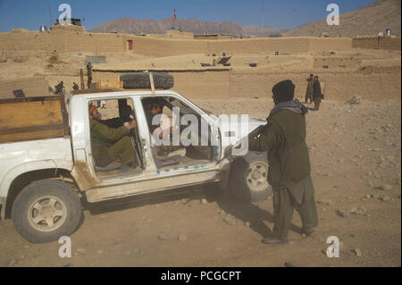 Un afghano di Polizia Locale candidato simula tirando su un veicolo durante un checkpoint per la formazione in classe Kajran distretto, Daykundi provincia, Afghanistan, 8 gennaio. La classe è parte di tre settimane di corso di formazione che descrive le principali procedure di polizia, armi di manipolazione e altre competenze necessarie per proteggere e difendere i cittadini afghani e garantire la stabilità nella regione. Foto Stock