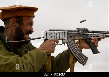 Un locale afghano di polizia incendi candidato suo AK-47 durante un'esercitazione a fuoco nel quartiere Kajran, Daykundi provincia, Afghanistan, gen. 13. La classe è parte di tre settimane di ALP corso di formazione che descrive le principali procedure di polizia, armi di manipolazione e altre competenze necessarie per proteggere e difendere i cittadini afghani e mantenere la stabilità nella regione. Foto Stock