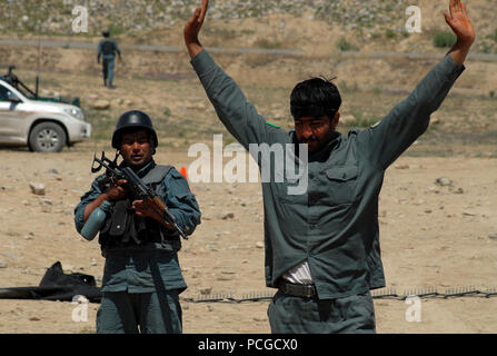 KABUL, Afghanistan (20 aprile 2010) - una nazionale afghano di ordine civile di polizia (ANCOP), Non-Commissioned Officer, sinistra, custodisce un pilota che è stato "preso in custodia" durante il controllo del traffico di formazione del punto in corrispondenza di un impianto di Kabul. I membri dell'élite forza di polizia ha ricevuto una formazione nel controllo del traffico e ingranaggio di comunicazioni che si preparano per le operazioni in Afghanistan. (US Navy Foto Stock