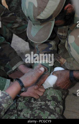 Esercito Nazionale Afghano soldati pratica pressione diretta medicazioni durante il training, 9 giugno. Questa istruzione incluso anche l'applicazione pratica del combattimento tourniquets. Foto Stock