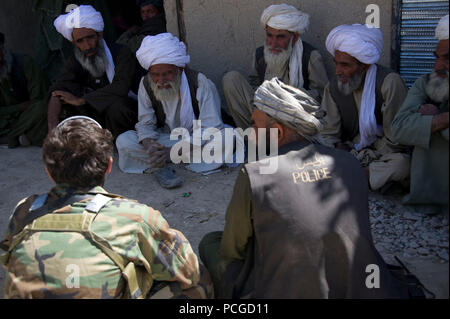 Gli anziani del villaggio di parlare con i membri dell'esercito nazionale afghano forze speciali afghane e la polizia locale circa i preparativi per la costruzione di un canale d'acqua per distretto Tagaw, provincia di Uruzgan, Afghanistan, 13 aprile. La canal garantisce che l'acqua raccolta durante l'estate durerà più a lungo e fornire più acqua di irrigazione come unità d'estate. Foto Stock