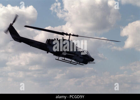 Una vista laterale destra di una utility di Marino/Attacco squadrone elicottero 169 (HML/A-169) AH-1W Sea Cobra elicottero volando sul golfo. L'elicottero è armato con un'AIM-9 missile Sidewinder. Foto Stock