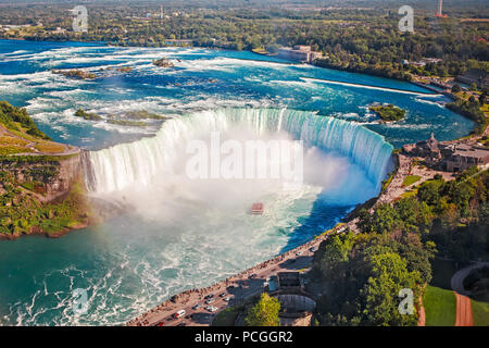 Antenna orizzontale superiore vista delle cascate del Niagara e tour in barca in acqua tra gli Stati Uniti e il Canada. Il ferro di cavallo della famosa cascata canadese sulla giornata di sole Foto Stock