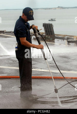 Petty Officer di terza classe Ryan Schuler, una di boatswain mate, spruzzi di acqua fresca sul ponte di volo durante un lavaggio agricoli giù a bordo del dock anfibio sbarco USS Carter Hall. Carter Hall ha recentemente sostenuto il funzionamento risposta unitaria dopo un terremoto di magnitudine 7.0 hanno provocato gravi danni in ed intorno a Port-au-Prince, Haiti gen. 12. ( Foto Stock