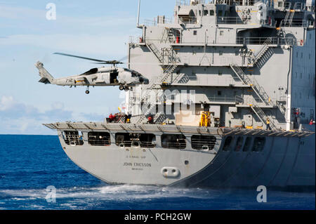 Oceano Pacifico (sett. 5, 2012) Una SH-60 Sea Hawk elicottero assegnati ai signori della guerra di elicottero Anti-Submarine luce (HSL) 51 preleva le forniture dal ponte di volo di militari Sealift il comando della flotta di oliatore di rifornimento USNS John Ericsson (T-AO 194) durante un rifornimento in corso con il Ticonderoga-class guidato-missili cruiser USS Cowpens (CG 63). Cowpens è parte del George Washington Carrier Strike gruppo, U.S. La marina è solo distribuito carrier strike gruppo, basati fuori Yokosuka, Giappone, e sta conducendo una routine Pacifico occidentale patrol. Foto Stock