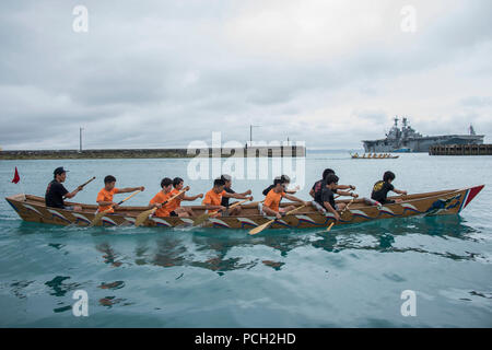 OKINAWA, in Giappone (15 aprile 2018) un team giapponese righe durante una gara di dragon boat alla spiaggia bianca di struttura navale come parte di spiaggia bianca Festival 2018. Il festival è un annuale, a base aperta evento ospitato da le attività della flotta e di Okinawa Japan Maritime Self Defence Force attività Sub-Area Okinawa, ed è progettato per ricambiare l'ospitalità che la comunità di Okinawa ha illustrato le forze statunitensi di stanza in Okinawa. Foto Stock