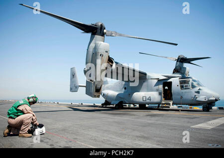 Mare Arabico (Agosto 7, 2012) Cpl. Ian pagina sistema esegue controlli di manutenzione su una MV-22B Osprey durante il volo quarti sul ponte di volo a bordo del multipurpose Amphibious Assault nave USS Iwo Jima (LHD 7). Iwo Jima con la avviato 24 Marine Expeditionary Unit è implementato per supportare le operazioni di sicurezza marittima e di teatro la cooperazione in materia di sicurezza gli sforzi negli Stati Uniti Quinta Flotta area di responsabilità. Foto Stock