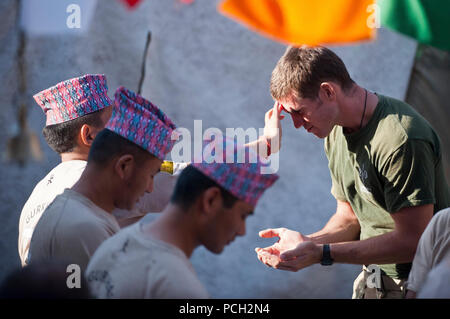 Un soldato Nepalese dal Royal Gurkha fucili reggimento dell'esercito britannico, Brigata di Gurkhas benedice un soldato britannico durante la festa di Dashain, a Lashkar Gah distretto, provincia di Helmand, Sett. 24. Il Royal Gurkha Rifles sono la sola unità Gurkha nell'esercito britannico. Dashain, un 15-giorno nazionale nepalese e religioso-festival ed è il paese????????s più lunga e la più promettente festival. Dashain commemora le vittorie della dea Durga oltre il demone Mahisasur, dea Durga è adorato in tutto il regno come la divina madre dea. Foto Stock