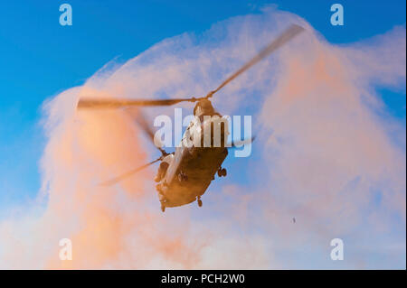 Un Royal Air Force HC2 elicottero Chinook vola attraverso il fumo che si prepara a terra alla base di pattuglia Jaker in Nahr-e Saraj distretto, provincia di Helmand, Afghanistan, Sett. 13, 2011. Foto Stock