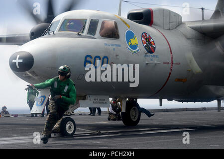 Stati Uniti 7TH FLOTTA AREA DI RESPONSABILITÀ (27 marzo 2013) di aviazione di Boatswain Mate (attrezzature) Airman Matteo Fulks corre dall'area di varo di una E-2C Hawkeye dal Golden Hawks di Airborne Early Warning Squadron (VAW) 112 a bordo della portaerei USS John C. Stennis (CVN 74). John C. Stennis è distribuito negli Stati Uniti 7 flotta area di responsabilità condurre le operazioni di sicurezza marittima, teatro di sicurezza gli sforzi di cooperazione. Foto Stock