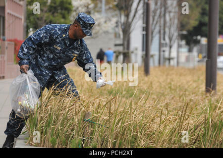 YOKOSUKA, Giappone (23 marzo 2013) Direttore Master-at-Arms Maurice Alcorn, assegnato per le attività della flotta Yokosuka, preleva il cestino in un area comune al di fuori dell'installazione. Alcorn, insieme con altri marinaio e membri della comunità Yokosuka, guidato da Yokosuka la coalizione dei marinai contro decisioni distruttive, trascorso il sabato pomeriggio la pulizia di aree al di fuori di attività della flotta Yokosuka. Foto Stock