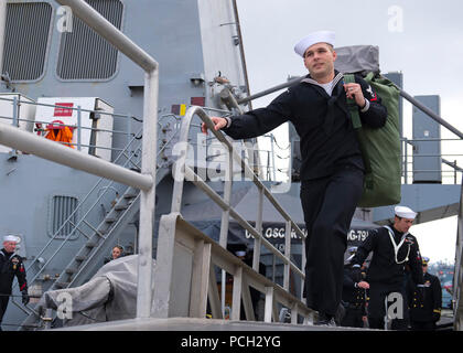 NORFOLK (feb. 17, 2013) marinai attraversare il fronte del Arleigh Burke-class guidato-missile destroyer USS Oscar Austin (DDG 79) Dopo la nave del ritorno alla stazione navale di Norfolk a seguito di sette mesi di distribuzione. Oscar Austin è stato implementato il supporto le operazioni di sicurezza marittima e di teatro la cooperazione in materia di sicurezza gli sforzi negli Stati Uniti Sesta flotta area di responsabilità. Foto Stock