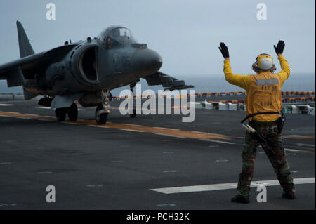 Oceano Pacifico (25 marzo 2013) un segnale di atterraggio guide arruolato AV-8B Harrier assegnato al Marine squadrone di attacco (VMA) 214 durante le operazioni di volo a bordo di un assalto anfibio nave USS Boxer (LHD 4). Il Boxer è in corso di addestramento al largo della costa della California del Sud. Foto Stock