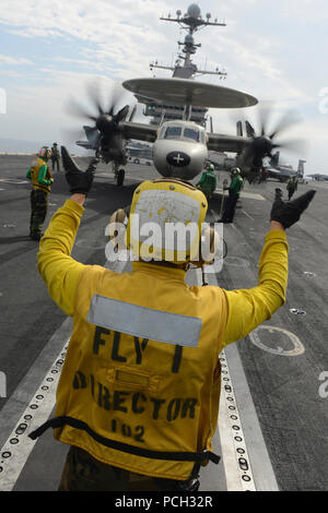 Mare Arabico (dec. n. 08, 2012) di aviazione di Boatswain Mate (movimentazione) terza classe Robert Vitolo, da Tuscon, Ariz., dirige un E-2C Hawkeye dal Golden Hawks di Airborne Early Warning Squadron (VAW) 112 a bordo della portaerei USS John C. Stennis (CVN 74). John C. Stennis è distribuito negli Stati Uniti Quinta Flotta area di responsabilità condurre le operazioni di sicurezza marittima, teatro la cooperazione in materia di sicurezza gli sforzi e le missioni di sostegno per l'Operazione Enduring Freedom. Foto Stock