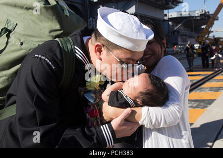 YOKOSUKA, Giappone (nov. 20, 2012) Aviation Electronics Tecnico 2a classe Richard Ching, da Honolulu, bacia il figlio dopo la portaerei USS George Washington (CVN 73) è tornato a Yokosuka, Giappone. George Washington e avviato Carrier aria Wing (CVW) 5 forniscono un combattimento-pronto forza che protegge e difende il collettivo di interesse marittimi degli Stati Uniti e dei suoi alleati e partner nella regione Asia-Pacifico. Foto Stock