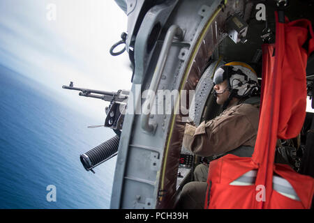 Oceano Pacifico (7 maggio 2018) Naval Air Crewman (elicottero) 2a classe Juan Morabarajas, da Oakland, in California, mans un .calibro 50 pistola della macchina all'interno di un MH-60S Sea Hawk elicottero assegnato per i caricatori di elicottero di mare squadrone di combattimento (HSC) 14. La portaerei USS John C. Stennis (CVN 74) è attualmente in corso con le navi e squadroni di Carrier Strike gruppo (CSG) 3 gruppo conduttore sail training in preparazione per la sua successiva installazione pianificata. Foto Stock