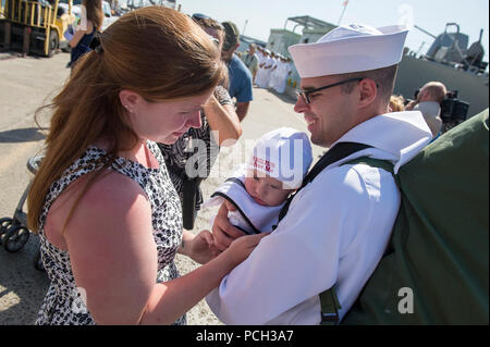 SAN DIEGO (Jun. 25, 2015) Tecnico Sonar (Superficie) 2a classe Matthew Clark incontra il suo figlio per la prima volta dopo 250 giorni di distribuzione indipendenti a bordo guidato-missile destroyer USS Milius (DDG 69). Milius sono transitati quasi 71.000 miglia nautiche durante la conduzione di operazioni di presenza e di buona volontà attività con le nazioni partner mentre distribuito negli Stati Uniti Il 5 e il 7 flotte. Foto Stock