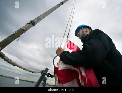 PYEONGTAEK, Repubblica di Corea (ott. 7, 2013) ShipХs soldati di terza classe Shelton Talaro si prepara a sollevare il jack della Marina Militare a bordo della distribuita Arleigh Burke-class missile destroyer USS Mustin (DDG 89). Mustin è di pattuglia con la George Washington Carrier Strike gruppo NEGLI STATI UNITI 7 flotta area di responsabilità il supporto di sicurezza e stabilità nella Indo-Asia-regione del Pacifico. Foto Stock