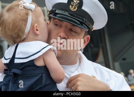 YOKOSUKA, Giappone (18 maggio 2015) Master Chief da elettricista, Mate Nathan Miller, virtuale interattivo attrezzature di formazione lead instructor a bordo della Nimitz-class portaerei USS George Washington (CVN 73), dice addio a sua figlia come la nave si prepara a partono le attività della flotta, Yokosuka per la sua pattuglia 2015. George Washington e la sua aria imbarcato ala, Carrier aria Wing (CVW) 5, fornire un contro-pronto forza che protegge e difende il collettivo agli interessi marittimi degli Stati Uniti e dei suoi alleati e partner in Indo-Asia-regione del Pacifico. Foto Stock