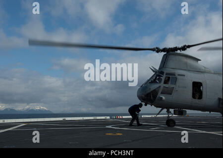 COOK INLET, Alaska (30 aprile 2013) Reparto aria marinai guarnitura e catena di un Marine Corps CH-46 Sea Knight elicottero al ponte di San Antonio-classe di trasporto anfibio nave dock unità Pre-Commissioning (PCU) ancoraggio (LPD) 23 si avvicina alla costa dell'Alaska. Ancoraggio è in rotta per il suo omonimo città di Anchorage in Alaska,, per la sua cerimonia di messa in servizio il 4 maggio. Foto Stock