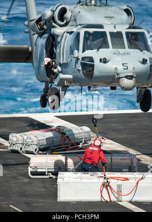 Oceano Pacifico (28 aprile 2013) un marinaio a bordo della portaerei USS Nimitz CVN (68) attribuisce al carico di un MH-60S Sea Hawk elicottero assegnato agli Indiani di elicottero di mare squadrone di combattimento (HSC) 6 durante la conduzione di un rifornimento in mare con la forza militare di comando Sealift carichi secchi e munizioni nave USNS Richard E. Byrd (T-AKE 4). Nimitz e Carrier aria Wing 11 sinistra San Diego per il Pacifico occidentale la distribuzione. Foto Stock