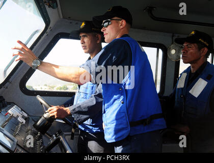 Petty Officer 2a classe Dustin Bailey, una di boatswain mate, incarica un membro di Dili della polizia marittima di manovra verso un recipiente di avvicinamento durante una formazione sulla sicurezza esercizio nel porto di Dili. Velisti assegnati all'assalto anfibio nave USS Peleliu e il dock landing ship USS Pearl Harbor stanno conducendo una due giorni di sicurezza marittima corso durante un cross-nazione di formazione militare di esercizio. Peleliu e Pearl Harbour sono assegnati a Peleliu anfibio gruppo pronto e partecipano in esercizio Crocodilo, un esercizio multilaterale che promuova la collaborazione attraverso programmi civili Foto Stock