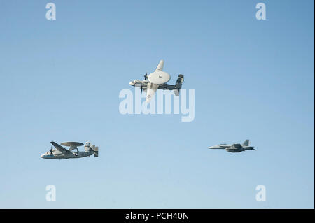 Un U.S. Navy E-2C Hawkeye aeromobile volato dalla Cmdr. John Hewitt, centro l'uscita ufficiale in comando di Carrier Airborne Early Warning Squadron (VAW) 126, un E-2C volato dalla Cmdr. Przemyslaw Kaczynski, sinistra, lo squadrone del comandante in entrata e un EA-18G Growler aeromobile volato da Capt. George Wikoff, il comandante del Carrier aria Wing (CVW) 3, partecipare a un cambiamento dell'antenna del comando cerimonia sulla portaerei USS Harry Truman (CVN 75) 18 marzo 2014, nel Golfo di Oman. L'Harry Truman Carrier Strike gruppo è stato distribuito negli Stati Uniti Quinta Flotta area di responsabilità il supporto Foto Stock