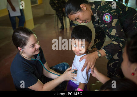 LIGAO City, Filippine (28 giugno 2016) Lt. Noelle Cadette, U.S. Navy infermiera assegnata alla nave ospedale USNS misericordia (T-AH 19), a sinistra e a seconda Lt. Irish F. Banaybanay, dall'infermiera filippina Corps, ascoltare un bambino di polmoni a Ligao Occidentale Centrale Scuola Elementare durante il partenariato del Pacifico 2016. Cadette, da Norwalk, Connecticut, è stata presso la scuola come parte di una cooperativa di impegno sanitario dove Pacific Partnership personale 2016 attaccata alla misericordia e i membri delle forze armate delle Filippine ha trascorso la giornata a educare le persone sulla sanità, igiene e nutrizione. I partecipanti hanno inoltre fornito d Foto Stock