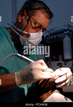 PORT-au-Prince, Haiti (sett. 4, 2007) - Air Force Lt. Col. Richard Tate, un dentista attaccato ai militari Sealift Command (MSC) nave ospedale USNS Comfort (T-AH 20) esegue una estrazione del dente su un paziente in corrispondenza di H™pital de lХUniversitЋ dХEtat dХHaiti. Il comfort è su quattro mesi di distribuzione umanitario per l America Latina e i Caraibi fornendo cure mediche ai pazienti in una dozzina di paesi. Stati Uniti Navy Foto Stock