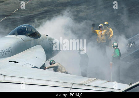 Un piano del gestore di segnali pilota da 'Pukin' Cani' di Strike Fighter Sqaudron (VFA) 143 sul ponte di volo dell'Nimitz-class portaerei USS Dwight D. Eisenhower CVN (69). La Eisenhower Carrier Strike gruppo (IKE CSG) e la sua aria wing, Carrier aria Wing (CVW) 7 e la USS John C. Stennis Carrier Strike gruppo (JCSSG) e la sua aria wing, Carrier aria Wing (CVW) 9, stanno conducendo una dual-carrier esercizio. Questo segna la prima volta che la Stennis e Eisenhower colpire i gruppi hanno operato insieme in un esercizio congiunto mentre distribuito negli Stati Uniti La marina di Quinta Flotta area di responsabilità. Questo e Foto Stock