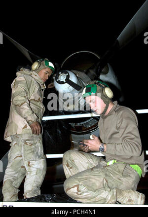 Aviazione del macchinista mate Airman Zaccaria Edwards aviazione e macchinista di mate Petty Officer di terza classe Daniel Childress eseguire interventi di manutenzione sul motore di un P-3C Orion aeromobili. Manutentori di aeromobili stanno lavorando per tutta la notte per mantenere i piani di missione pronto. Foto Stock