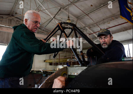 Garnett "Lee" Ovest (a destra) e Joseph Walther posizionare un restaurato la staffa attuale per un progetto di restauro. Entrambi gli uomini volontario presso la USS Midway Museo Centro di Restauro ripristino smantellata vintage aerei militari per public display a bordo della USS Midway Museum. Foto Stock