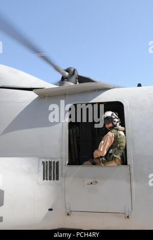 Marine Corps Staff Sgt. Jenna Kumdh, dal mezzo marino Tiltrotor Squadron 162, guarda fuori dalla finestra di una MV-22 Osprey, guardando per altri aeromobili sulla linea di volo a U.S. Stazione navale di Guantánamo Bay, 24 gen. Il velivolo, programmata per volare alla USS Bataan con forniture per Haiti è qui a sostegno del funzionamento risposta unitaria. Foto Stock