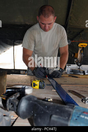 GUANTANAMO Bay a Cuba - Air Force Staff Sgt. Gary Learmonth, della 474th Expeditionary Ingegneria Civile Squadron, Base di emergenza forza ingegnere, Joint Task Force Guantanamo, misure di un pezzo di legno compensato prima di iniziare il ciclo di sezionatura in Camp giustizia, 16 marzo 2010. Il 474th ECES mantiene la Expeditionary complesso giuridico, di vitale importanza per la JTF missione. JTF Guantanamo conduce al sicuro, umano, legale e trasparente di cura e custodia dei detenuti, compresi quelli condannati dalla commissione militare e quelli ordinati rilasciato da un tribunale. La JTF conduce la raccolta di intelligence, analisi e diffusione per il protecti Foto Stock