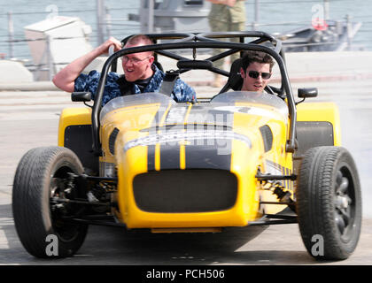 Stati Uniti 5TH FLOTTA AREA DI RESPONSABILITÀ (17 aprile 2013) - Un marinaio assegnato alla USS Typhoon (PC 5) prende un giro in una miniatura race car con American F1 driver Alexander Rossi di Caterham Racing. Rossi ha trascorso la giornata con gli Stati Uniti Le unità della marina militare in Bahrain e verrà a correre in Formula Uno Gulf Air Bahrain Grand Prix 2013 aprile 19. Foto Stock