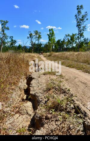 Forature profonde in una strada sterrata a causa di pioggia danni, Townsville, Queensland, Australia Foto Stock
