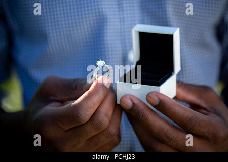 L'uomo africano tenuta anello di innesto e scatola Foto Stock