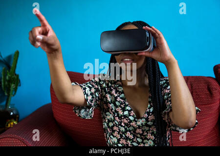 Donna africana guardando attraverso le cuffie VR Foto Stock