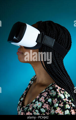 Vista di profilo di una donna africana guardando attraverso le cuffie VR Foto Stock