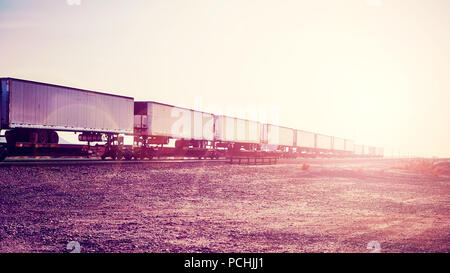 Trasporto merci intermodale, semirimorchi sul treno al tramonto, dai toni di colore immagine, STATI UNITI D'AMERICA. Foto Stock