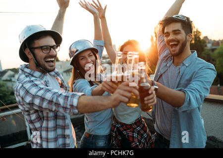 Gruppo di amici felice avente parte sul tetto Foto Stock